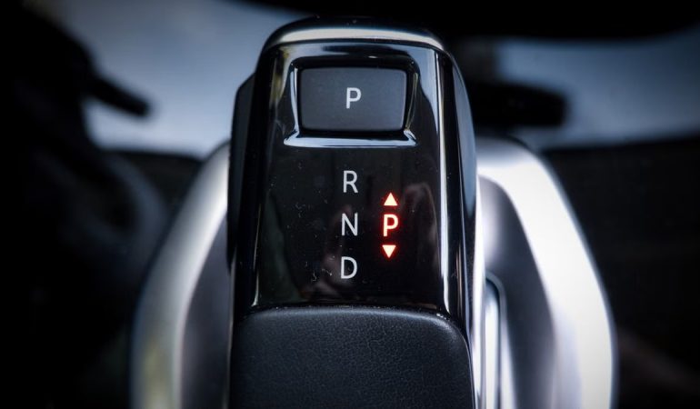 Detailed view of a modern automatic car gear shifter displaying P, R, N, D settings.